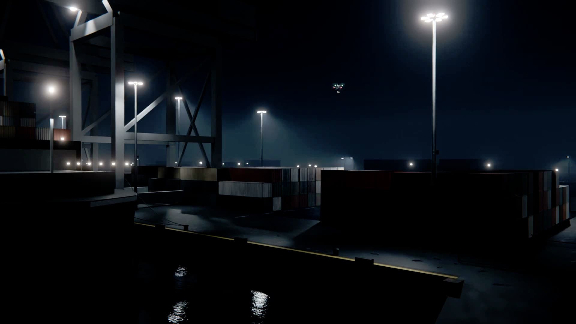 A container quay at night under the cranes, a small drone over the stacks