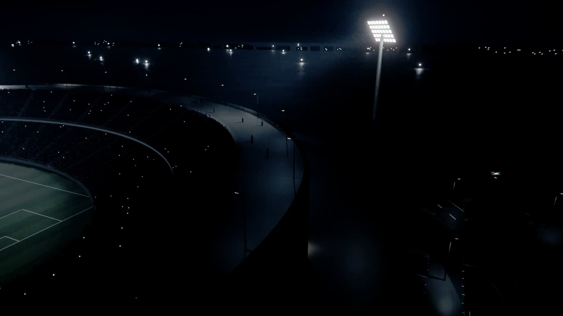 A stadium at night seen from above its outer wall, the pitch lit, floodlights along the rim