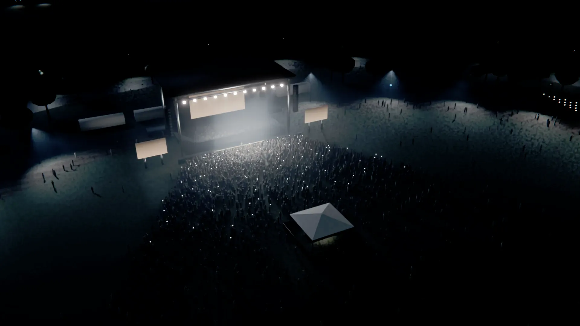 An open-air event ground at night, seen from above: a crowd on a lawn in front of a lit stage, ringed by trees and light poles, some of them carrying sensors.